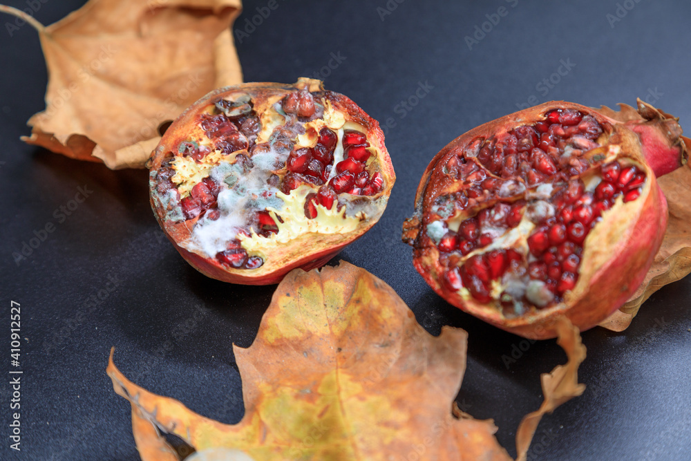 A closeup shot of cut pomegranate and dried leaves A closeup shot of cut pomegranate and dried leaves