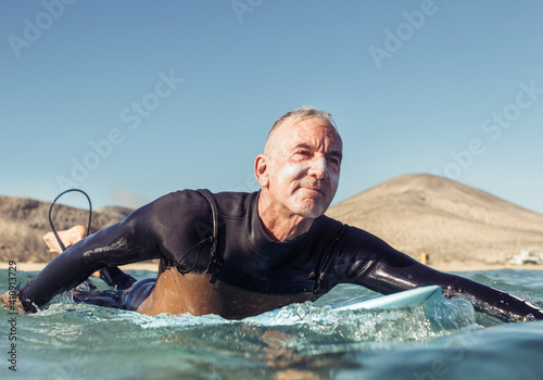 Mature man surfing in the sea
