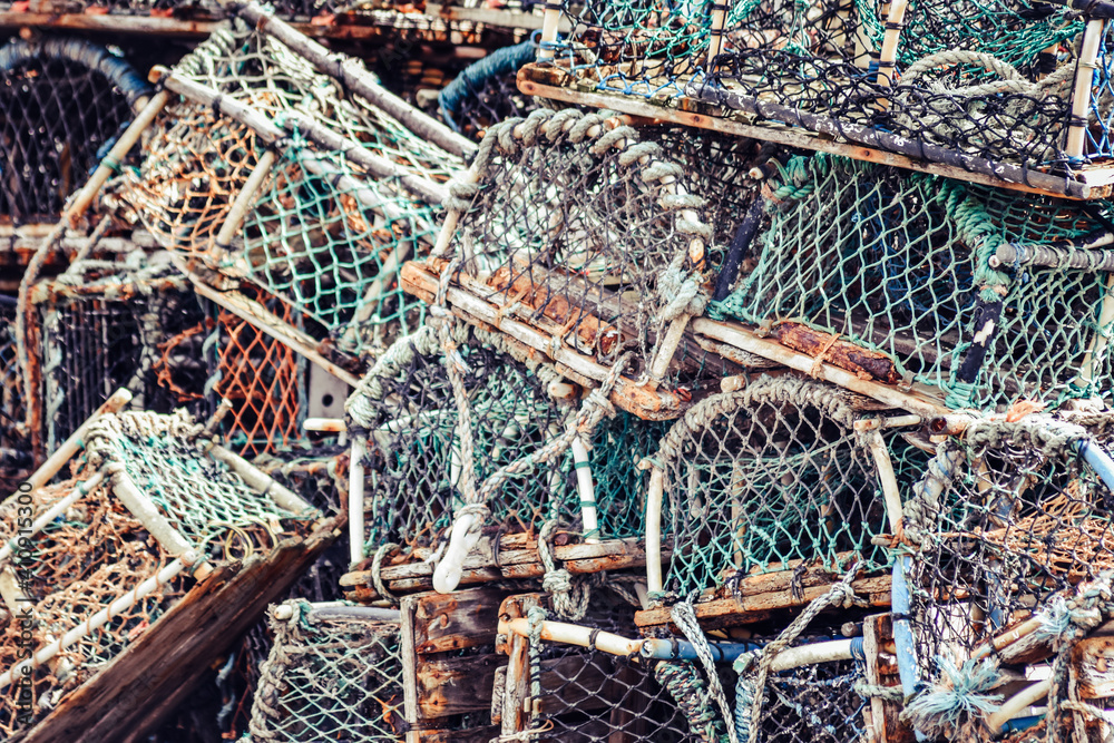 Lobster and crab pots traps stacked on harbour. Fishing industry in Whitby, England, United Kingdom.