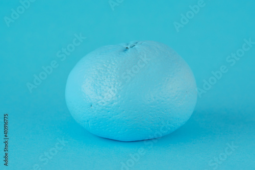 Turquoise tangerine on a turquoise background. Fake and disguise concept