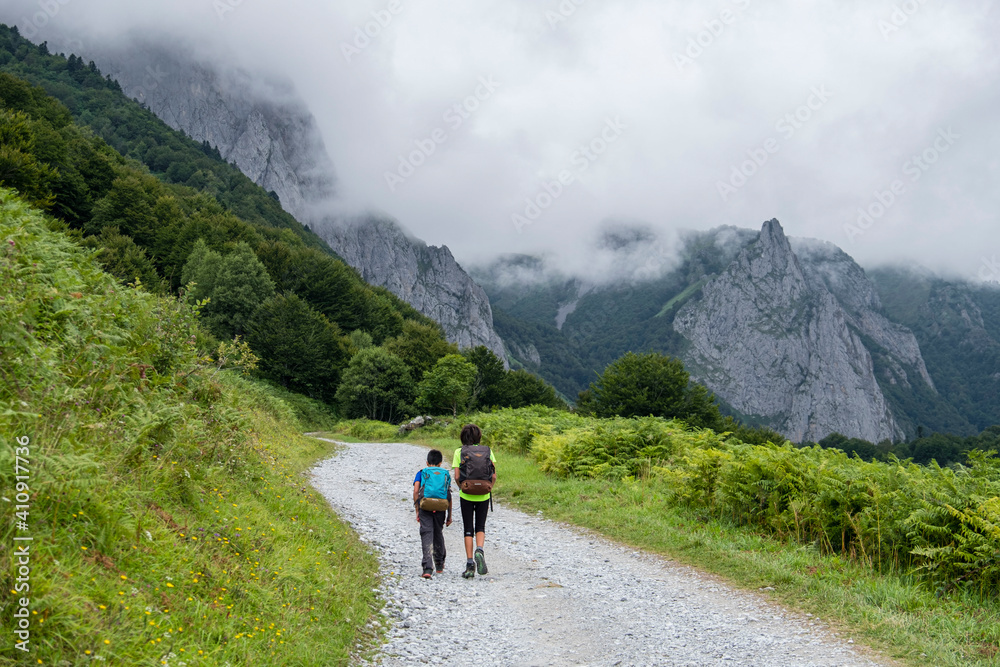 dos niños andando por la pista de Anapia a prados de Sanchese, trekking de las Golondrinas, Lescun, región de Aquitania, departamento de Pirineos Atlánticos, Francia