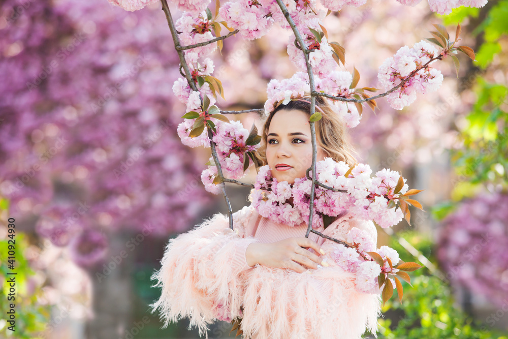 the girl is standing under the pink tree that bloom