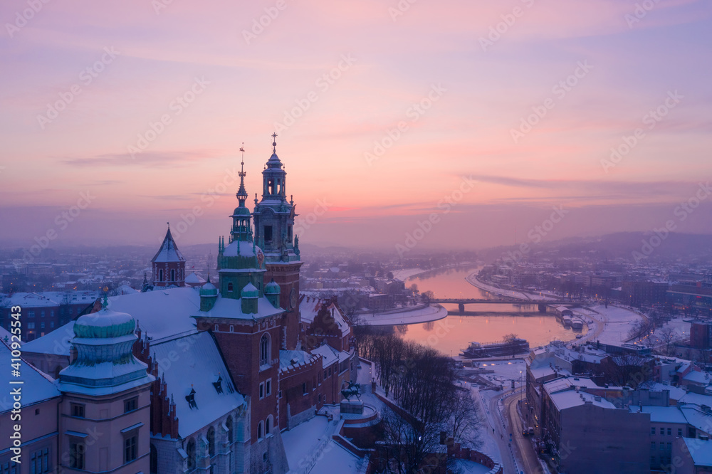 Wawel Royal Castle in winter. Snow on roofs of Wawel castle cathedral and Vistula river in Krakow Poland city center at sunset.