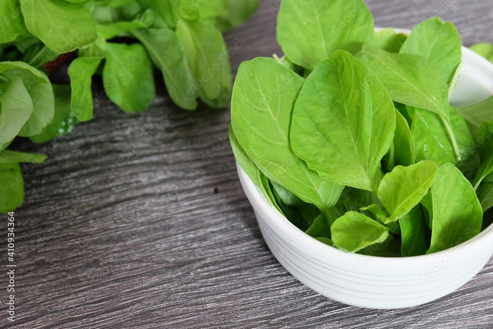 Fresh and raw spinach on a white bowl.
Fresh and raw spinach on a white bowl.