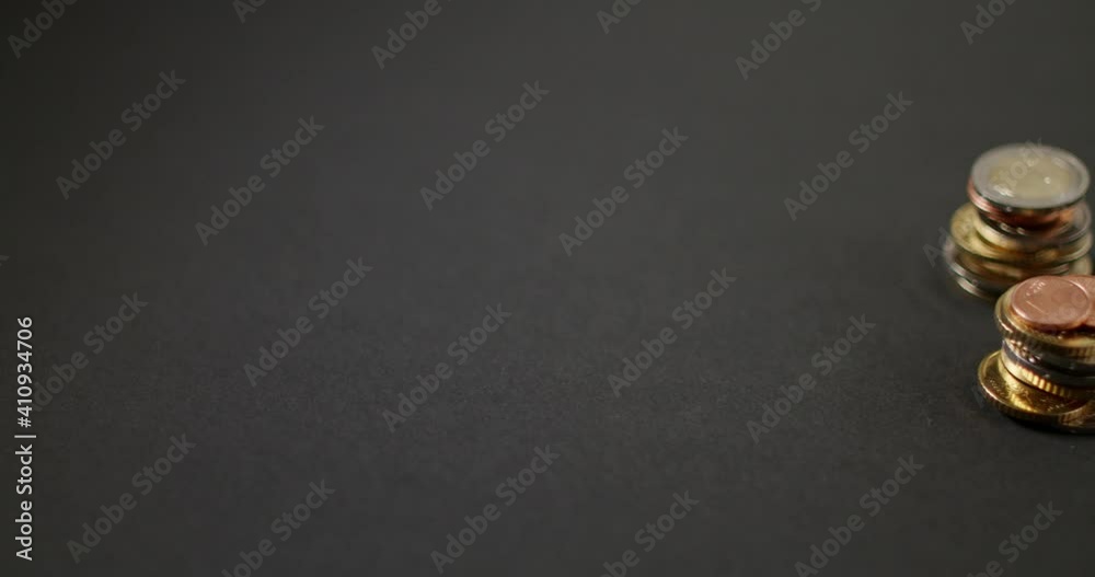 Panning away from stacked Euro coins over to black Background. Copyspace for text
