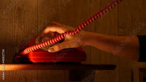 Close-up of a woman's hand ringing a vintage phone