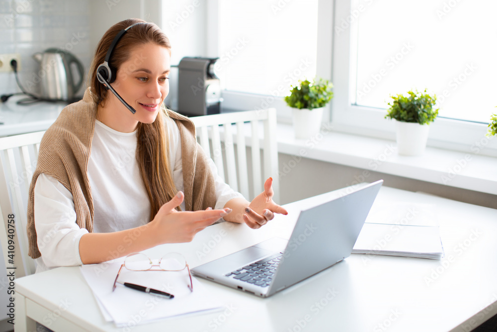 Smiling woman in front of laptop monitor during online conversation. Remote working concept. Smiling woman in front of laptop monitor during online conversation. Remote working concept.