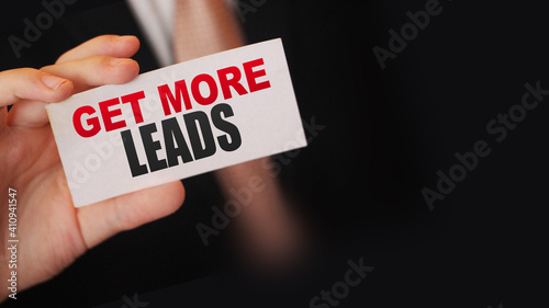 Businessman holding a card with text Get more leads. Business concept