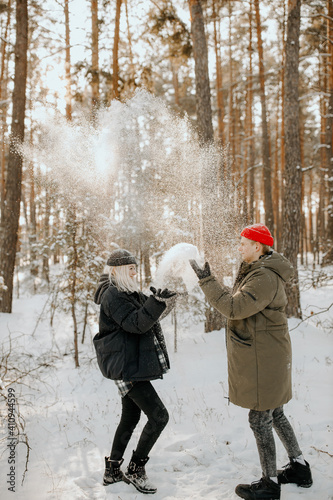 Young couple playing with snow and kissing and hugs