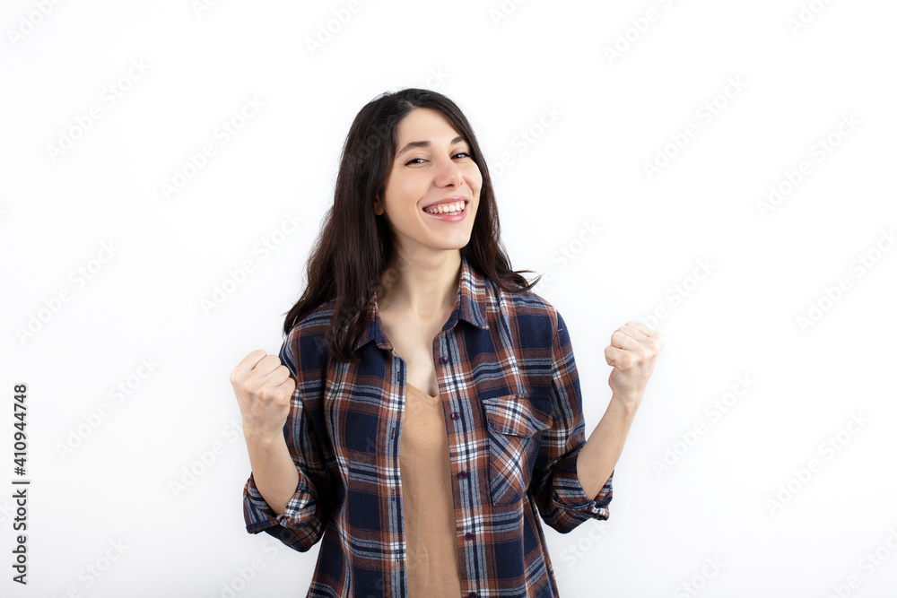 Young woman standing over isolated white background very happy and excited doing winner gesture with arms raised, smiling and screaming for success. Celebration concept. Young woman standing over isolated white background very happy and excited doing winner gesture with arms raised, smiling and screaming for success. Celebration concept.