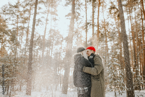 Young couple playing with snow and kissing and hugs