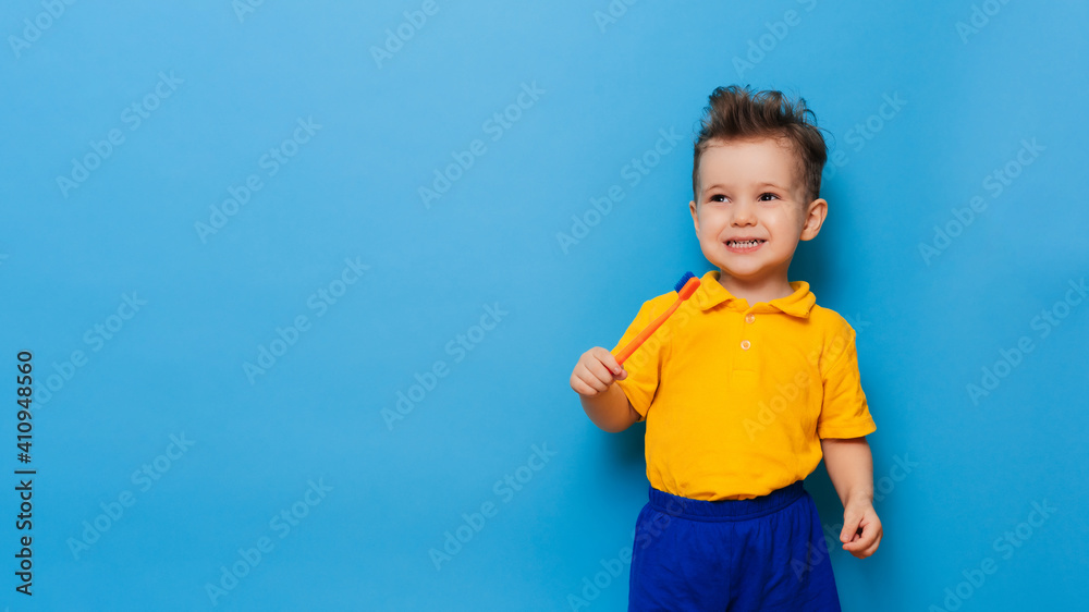 Happy child kid boy brushing teeth with toothbrush on blue background. Health care, dental hygiene. Mockup, copy space Happy child kid boy brushing teeth with toothbrush on blue background. Health care, dental hygiene. Mockup, copy space