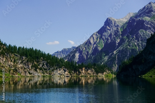 mountain lake with nice reflection and high rocky mountains in the background