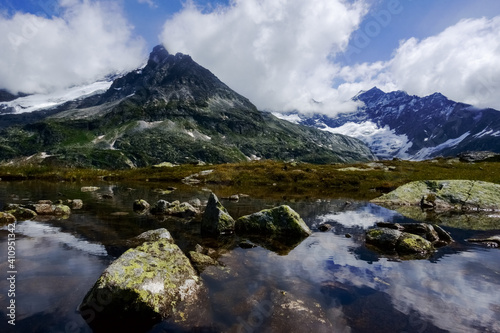 little pond with rocks and reflections from the mountains © thomaseder