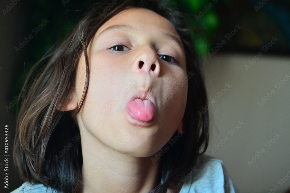 Portrait Of Cute Girl Sticking Out Tongue While At Home Stock Foto