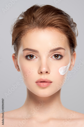 Spot of cosmetic cream on a woman's face. Beautiful face of young caucasian woman with perfect healthy skin, isolated.   Pretty white model caring of face. © Valua Vitaly