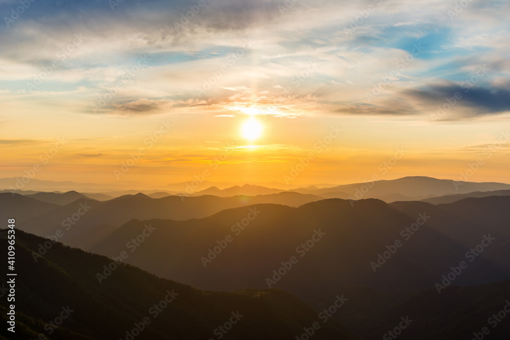 Naklejka premium The first or last rays of the sun on a mountain pass. Morning and evening in nature. Colorful sunset and sunrise over the mountain hills. Carpathians in summer and autumn.
