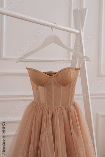 wedding dress of the bride weighs by the window, beautiful wedding dress on a hanger