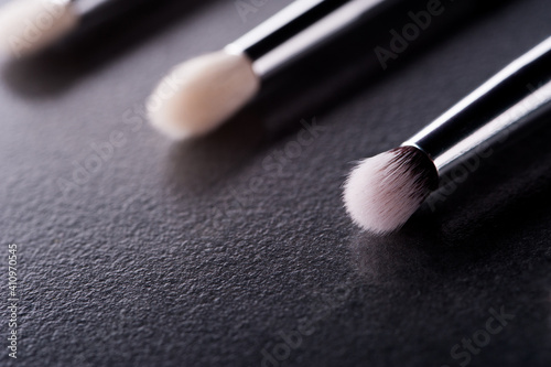 Make up brush lie on a black background 