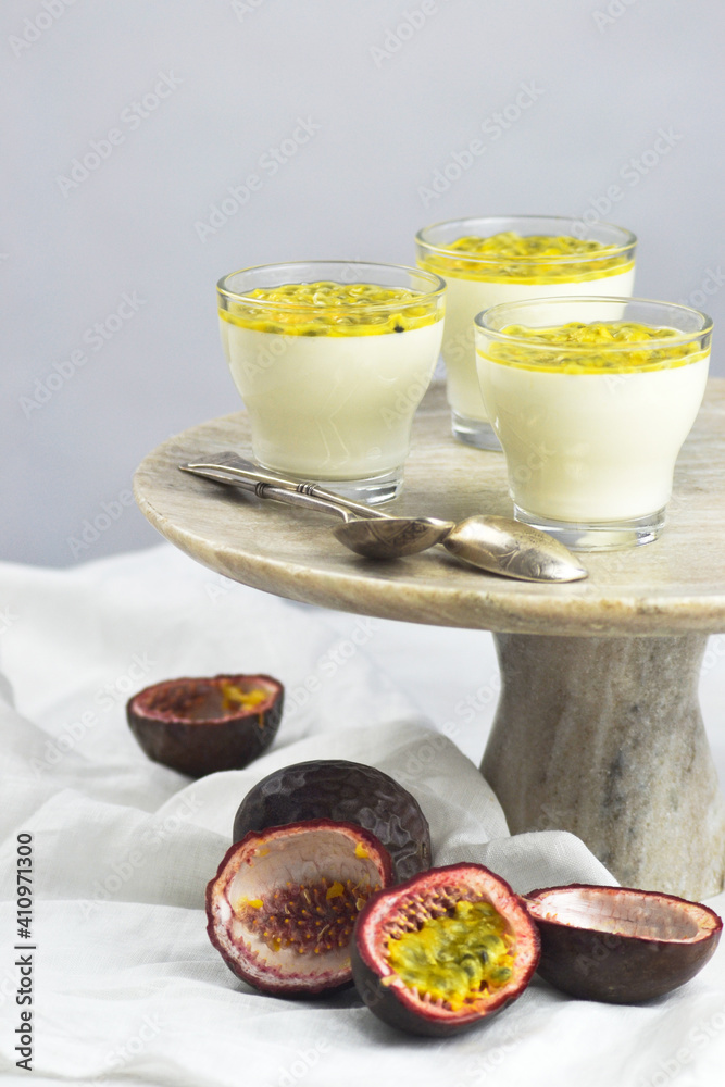 Italian dessert panna cotta in a glass cups with fresh passion fruits on a cake stand. Italian dessert panna cotta in a glass cups with fresh passion fruits on a cake stand.