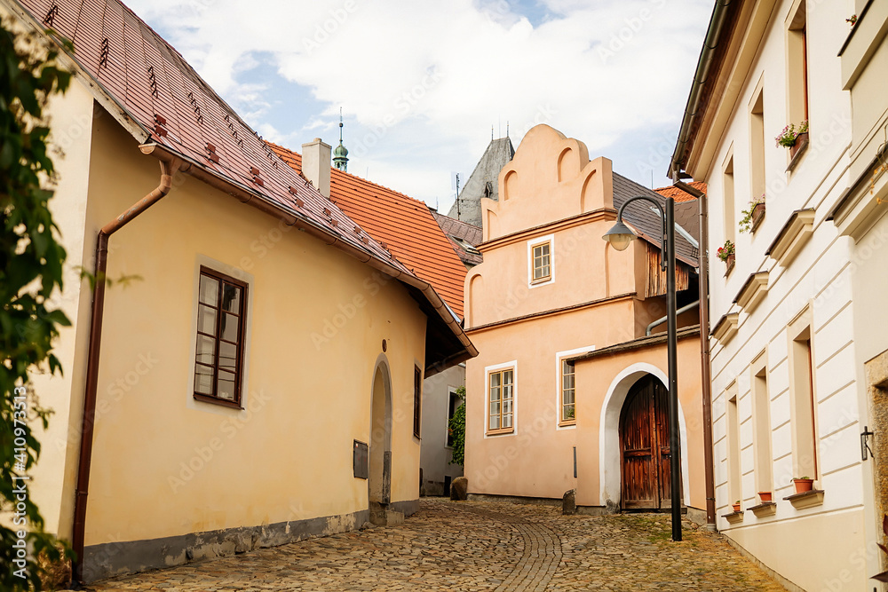 Narrow medieval picturesque street with baroque and renaissance historical buildings in sunny summer day, beautiful cityscape of medieval town, Tabor, South Bohemia, Czech Republic