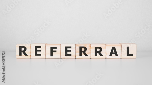 Word REFERRAL written on wood block. Business concept