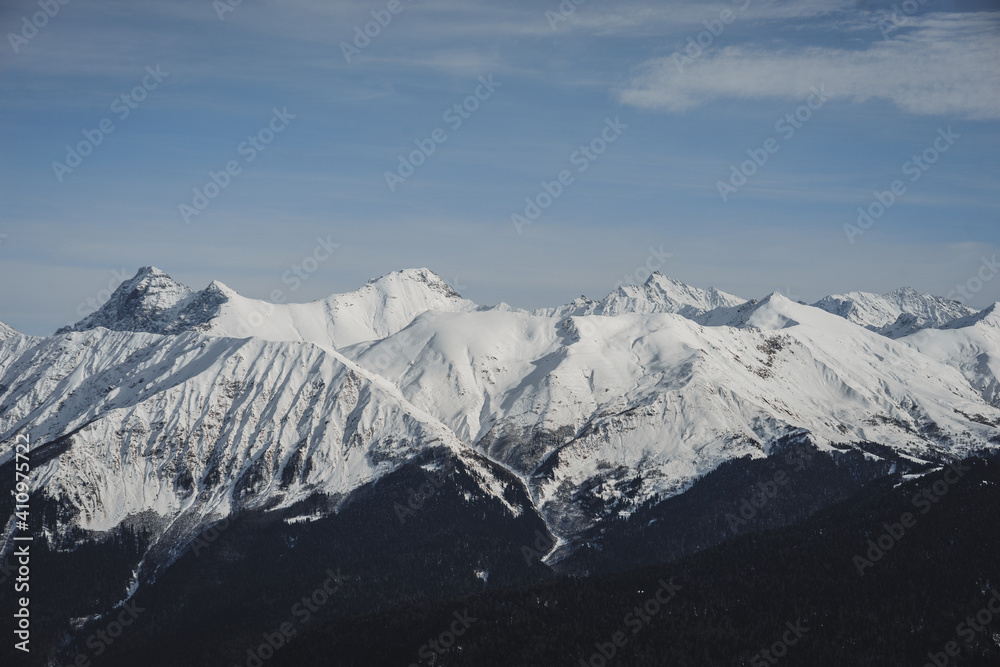 Alpine landscape, slopes of high mountains with glaciers against the blue sky.