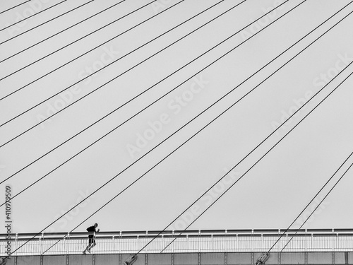 Hombre corriendo a traves de un puente colgante 