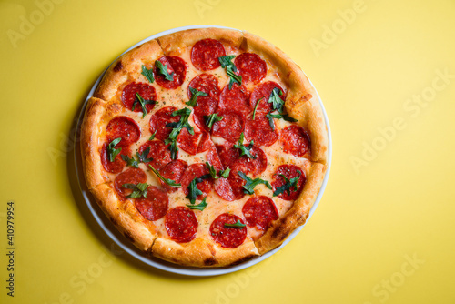 Pepperoni pizza centered on yellow background