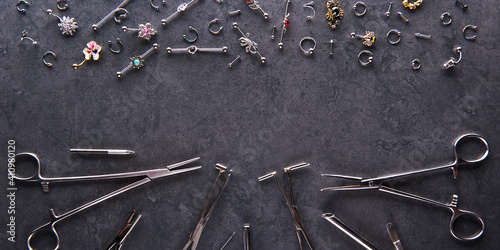 Bild auf Leinwand Piercing earrings, stainless steel clips for disinfection on a black background
