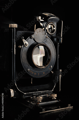 Vintage camera on a black background. Close-up of the lens of an old camera open.