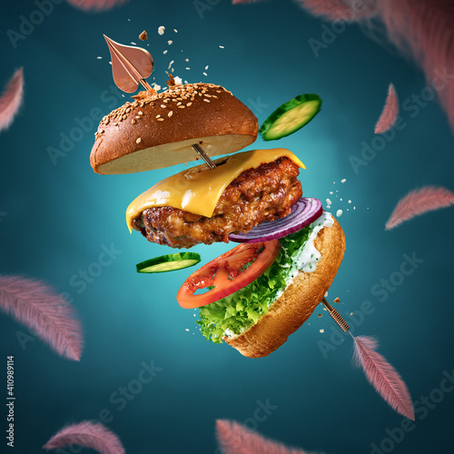 Delicious burger with flying ingredients and sauce. Valentine\'s day poster. Cupid\'s arrow pierces the burger. For the love of food. Blue background with flying feathers