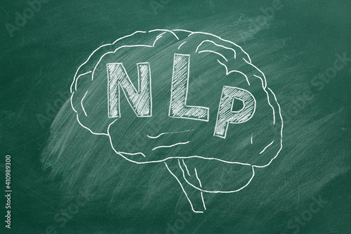 Human brain with abbreviation NLP hand drawing in chalk on blackboard. Neuro-linguistic programming. photo