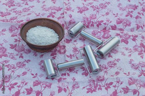 Roller pins metal on a background of a pink tablecloth.