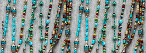 Horizontal repeatable banner of burlap with turquoise and silver beaded strands -- background