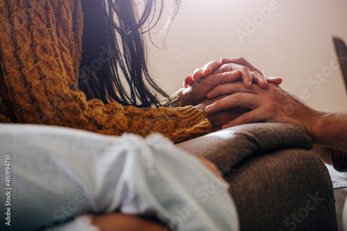 Fotografija Close up view young loving couple seated together on couch holding hands, gestur
