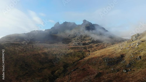 A slow panning shot of the Cobbler in the Highlands of Scotland peaking above the clouds.