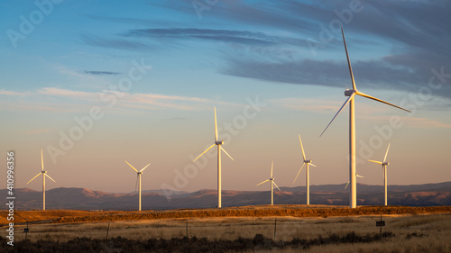 Wind turbines on a calm evening in golden light in Kittitas County in central Washington State wait for the pressure to change over the Cascade Mountains
