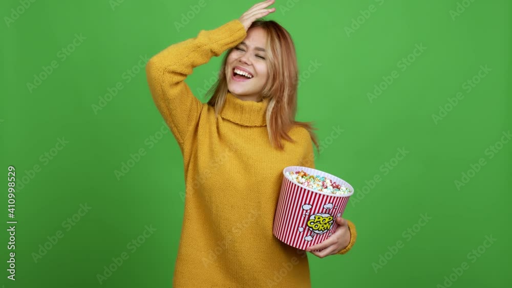 Teenager girl holding a bowl of popcorns intending to realizes the solution while lifting a finger up over isolated background Teenager girl holding a bowl of popcorns intending to realizes the solution while lifting a finger up over isolated background