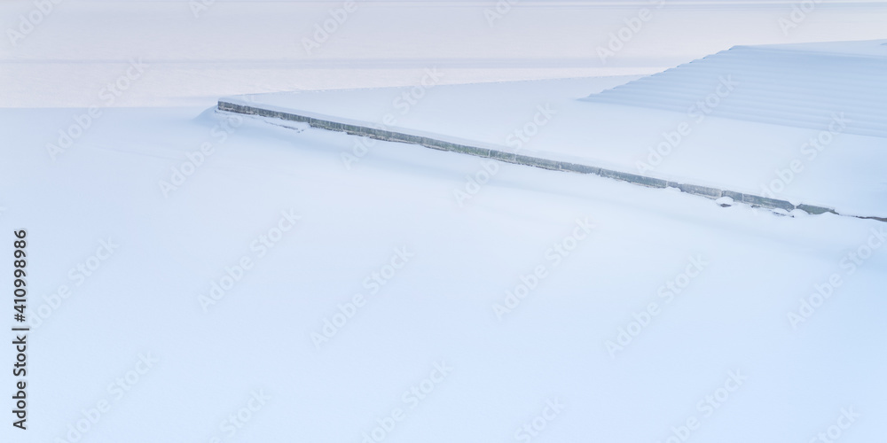 Snow-covered embankment, granite steps and ice surface Snow-covered embankment, granite steps and ice surface