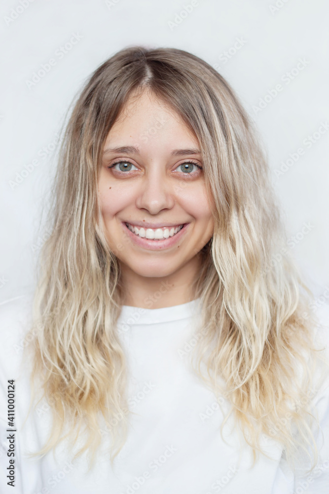 Portrait of a caucasian happy smiling girl with wavy hair in a white t-shirt on an isolated white background. Real sincere emotions. Young woman with a beautiful smile. Natural beauty without makeup Portrait of a caucasian happy smiling girl with wavy hair in a white t-shirt on an isolated white background. Real sincere emotions. Young woman with a beautiful smile. Natural beauty without makeup