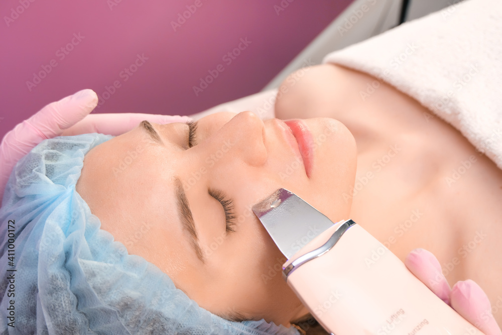 Fototapeta premium ultrasonic cleaning of the face of a young woman