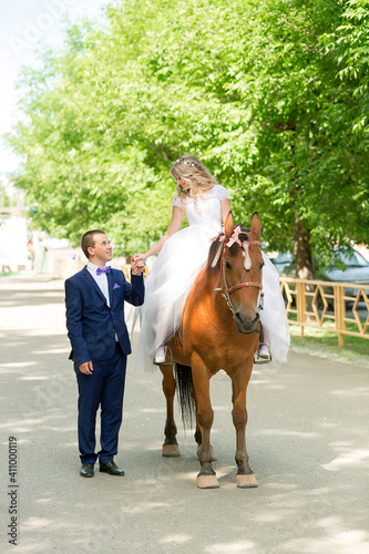 beautiful loving young couple groom and bride riding a horse