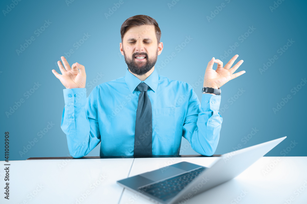 bearded businessman meditates in the office at the computer bearded businessman meditates in the office at the computer