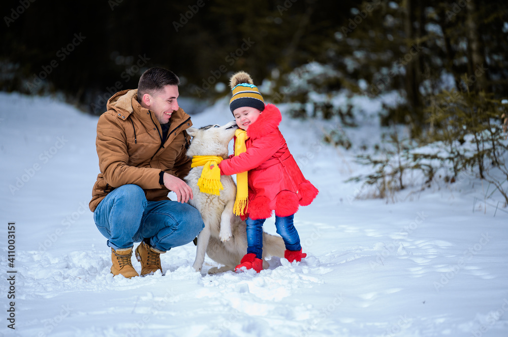 Happy father and little daughter and husky dog in winter forest walking in winter.