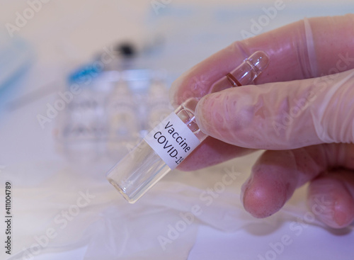 Medical doctor or laborant holding tube with nCoV Coronavirus vaccine for 2019-nCoV COVID virus.