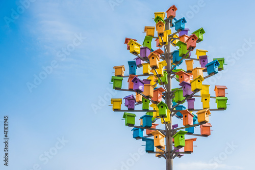 Many colorful birdhouses among the houses. photo