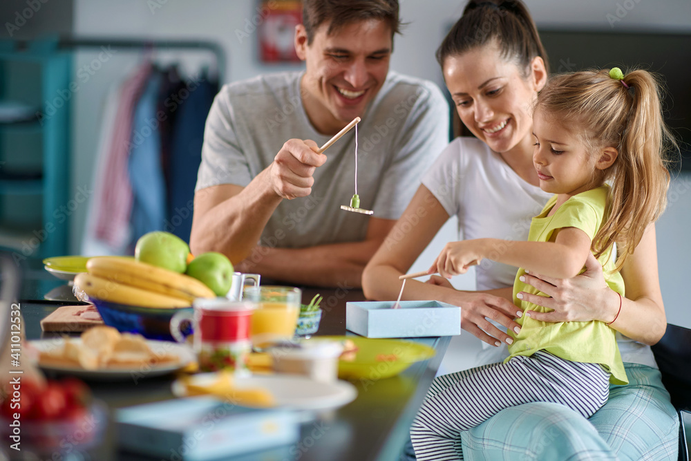 A young family enjoying games during a breakfast at home. Family, breakfast, together, home A young family enjoying games during a breakfast at home. Family, breakfast, together, home