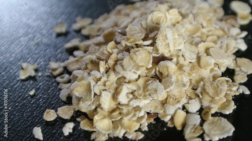A small portion of oatmeal rotating on a black background, macro shot