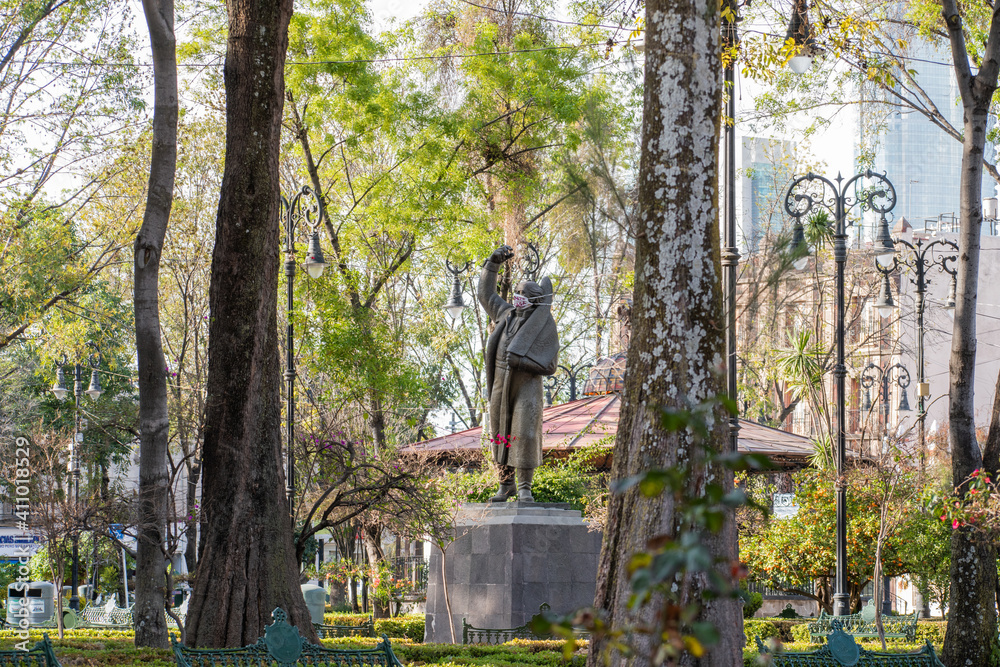 Statue of Mexican historical figure wearing face masks in park Statue of Mexican historical figure wearing face masks in park